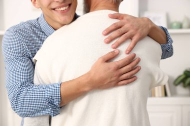 Baba ve oğul birbirlerine sarılıp yakınlaşıyorlar.