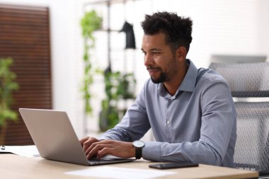 ofiste masada dizüstü bilgisayarda çalışan adam
