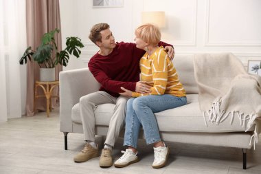 Evladının evdeki kanepesinde annesine sarılması.