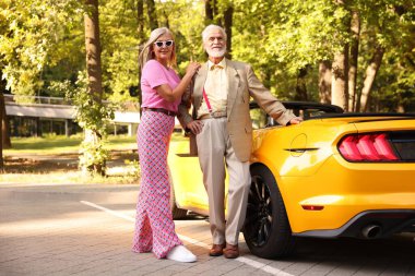 Modern Cabriolet yakınlarında şık bir yaşlı çift.