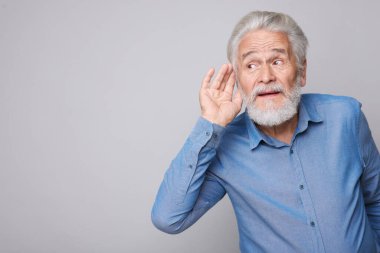 Açık gri arka planda işitme sorunu olan son sınıf öğrencisi. Metin için boşluk