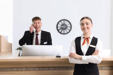 Otel resepsiyonunda resepsiyonist ve hostes, seçici odak