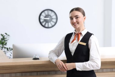 İçerideki resepsiyonda üniformalı mutlu resepsiyonist.