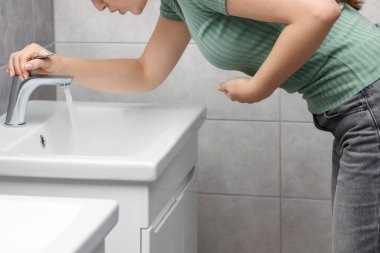 Lavaboda mide bulantısı çeken kadın, yakın plan.
