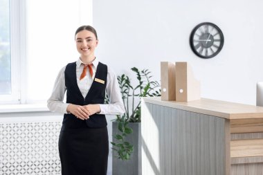 İçerideki resepsiyonda üniformalı mutlu resepsiyonist.