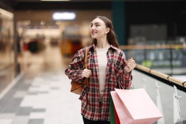 Alışveriş merkezinde farklı alışveriş torbaları olan bir kadın, mesaj için yer.