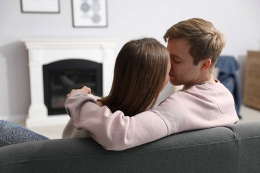 Kanepede şömineli sevimli bir çift