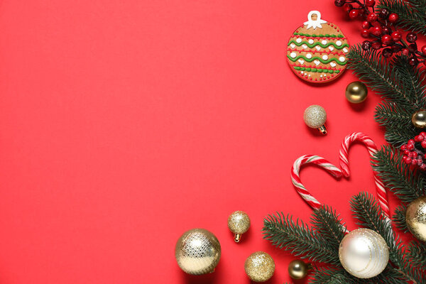 Плоская композиция с елочными ветвями, рождественским декором, печеньем и леденцами на красном фоне. Пространство для текста