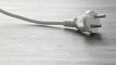 Kadın, ahşap masada elektrik prizinin yanına avro banknotları koyuyor, yakın plan.