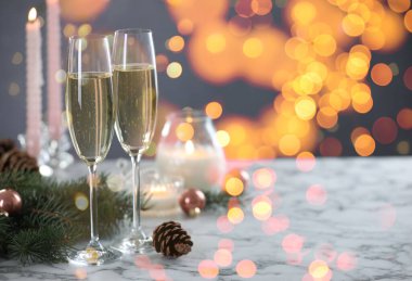 Bardakta köpüklü şarap, şenlikli dekor, ışık. Yeni yıl tebrik kartı.