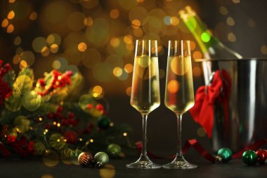 Bardakta köpüklü şarap, şenlikli dekor, ışık. Yeni yıl tebrik kartı.