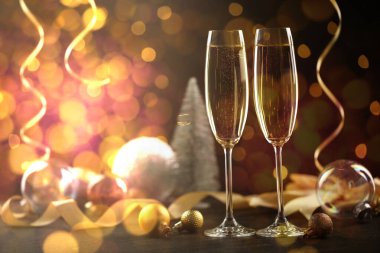 Bardakta köpüklü şarap, şenlikli dekor, ışık. Yeni yıl tebrik kartı.