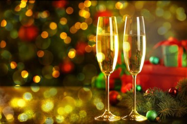 Bardakta köpüklü şarap, şenlikli dekor, ışık. Yeni yıl tebrik kartı.