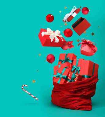 Noel baloları, hediye kutuları ve mavi arka planda çantaya konfetiler düşüyor.