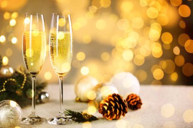 Bardakta köpüklü şarap, şenlikli dekor, ışık. Yeni yıl tebrik kartı.