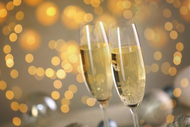 Bardakta köpüklü şarap, ışık. Yeni yıl tebrik kartı.