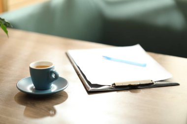 Kahve molası. Bir bardak aromatik içecek, pano ve kalem kapalı masa üzerinde. Metin için boşluk