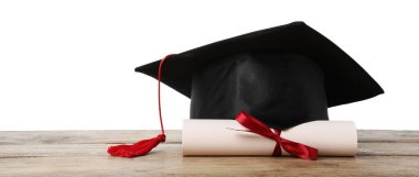 Mezuniyet şapkası ve diploması beyaz arka plana karşı ahşap masada.