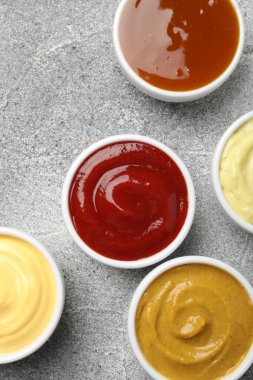 Gri masadaki tabakta farklı lezzetli soslar var.