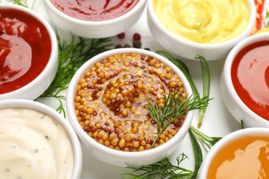 Beyaz masada farklı soslar ve otlar, yakın plan.