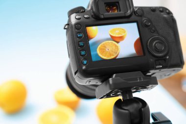 Stüdyoda kamerayla taze portakal çekmek, seçici odaklanma. Profesyonel yemek fotoğrafçılığı.