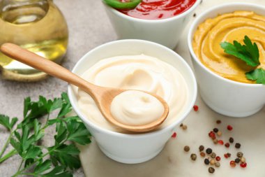 Farklı soslar, baharatlar ve bitkiler ışık masasında, yakın plan.