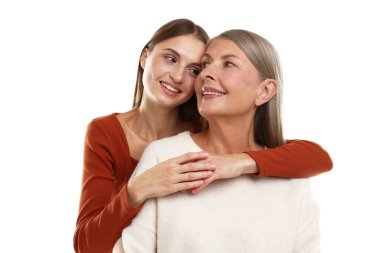 Kızı beyaz arka planda annesine sarılıyor.