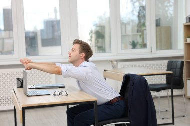 Genç işadamı ofiste kollarını açıyor.