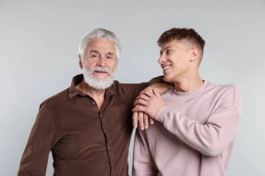 Açık gri arka planda baba ve oğulun portresi