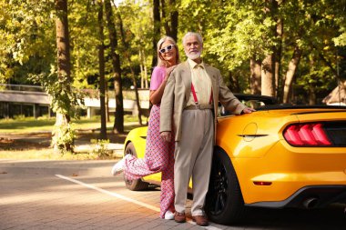 Modern Cabriolet yakınlarında şık bir yaşlı çift.