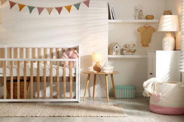 Beşik ve şifoniyerli şık bir bebek odası. İç tasarım