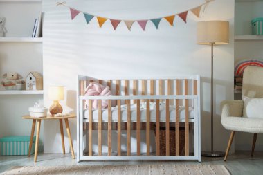 Bebek odası, beşik, masa ve lamba. İç tasarım