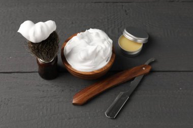 Gri ahşap arka planda farklı berber aletleri, yakın plan.