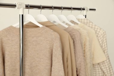 Arka planda askıda asılı farklı kıyafetler, yakın plan