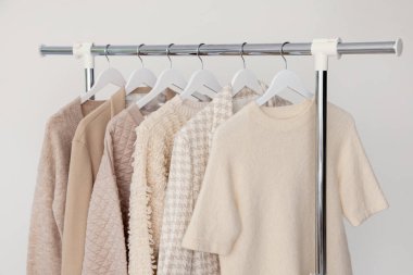 Arka planda askıda asılı farklı kıyafetler, yakın plan