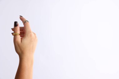 Beyaz arka planda şık yüzükler takan genç bir kadın, yakın plan. Metin için boşluk