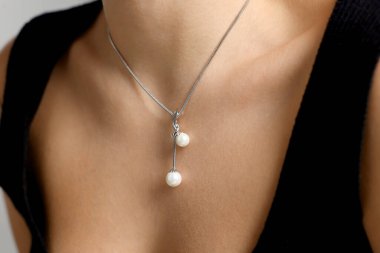 Yakından bakınca şık bir kolye takan bir kadın görülüyor.