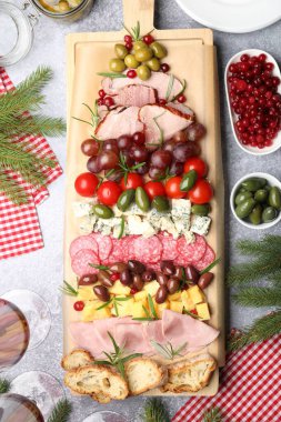 Gri desenli masa üzerinde çerez ve köknar dallarıyla nefis bir Noel Şarküteri tahtası.