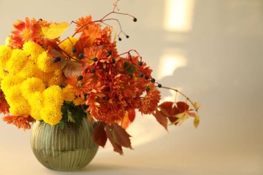 Sonbahar atmosferi. Güzel çiçekli vazo ve bej arka planda böğürtlen, yakın plan. Metin için boşluk