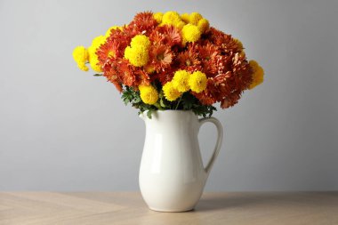 Sonbahar atmosferi. Tahta masanın üzerinde güzel çiçekleri olan vazo.