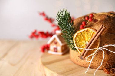Noel yemeği. Lezzetli Panettone pastası, baharatlar, zencefilli kek evi ve ahşap masada şenlikli bir dekor, yakın plan. Metin için boşluk