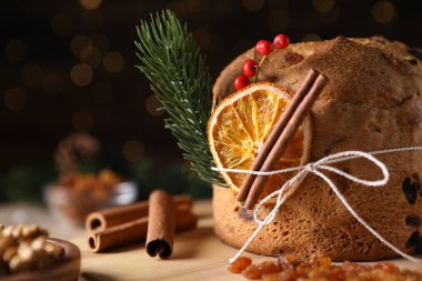 Noel yemeği. Lezzetli Panettone pastası, malzemeler ve arka planda arka planda bulanık ışıklarla süslü bir dekor, mesaj için yer. Bokeh etkisi