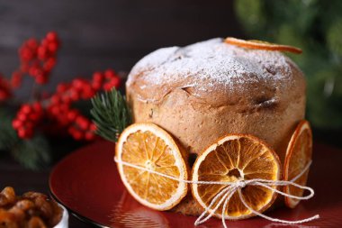 Noel yemeği. Lezzetli Panettone pastası, malzemeler ve sofrada şenlikli bir dekor, yakın plan.
