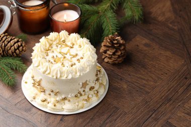 Noel dekorlu lezzetli pasta ve ahşap masada yanan mumlar. Metin için boşluk