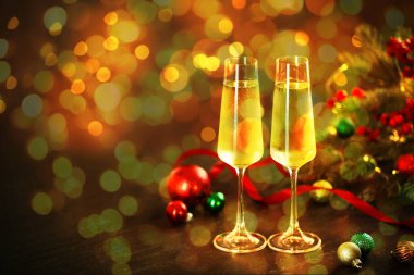 Bardakta köpüklü şarap, şenlikli dekor, ışık. Yeni yıl tebrik kartı.