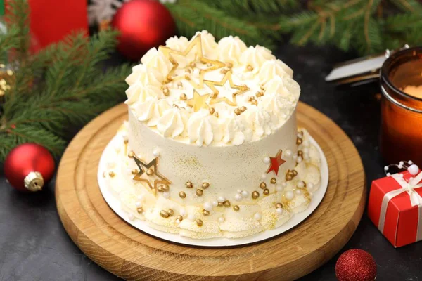 Noel dekorlu lezzetli pasta ve siyah masada yanan mum, yakın plan.