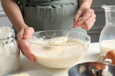 Beyaz masada hamuru hazırlayan kadın, yakın plan.