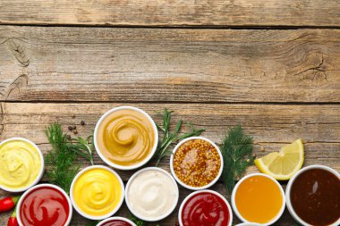 Tabaklardaki farklı soslar ve ahşap masa üzerindeki malzemeler. Metin için boşluk