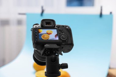 Stüdyoda kamerayla taze portakal çekmek, seçici odaklanma. Profesyonel yemek fotoğrafçılığı.