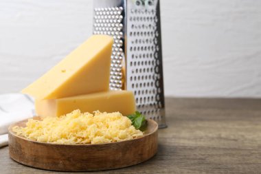 Tahta masada rendelenmiş peynir ve fesleğen parçaları, yakın plan. Metin için boşluk